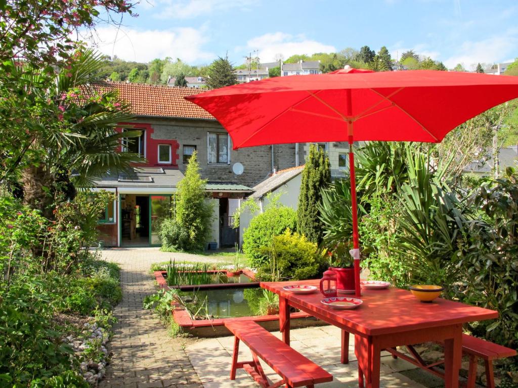una mesa de picnic roja con una sombrilla roja en Holiday Home L'Oté rouge - PLX105 by Interhome, en Plérin