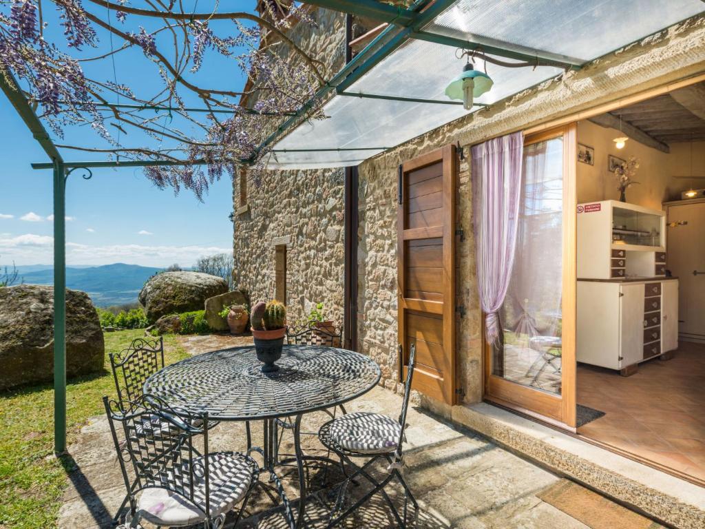 patio ze stołem i krzesłami oraz kuchnią w obiekcie Holiday Home La Casetta by Interhome w mieście Sassofortino