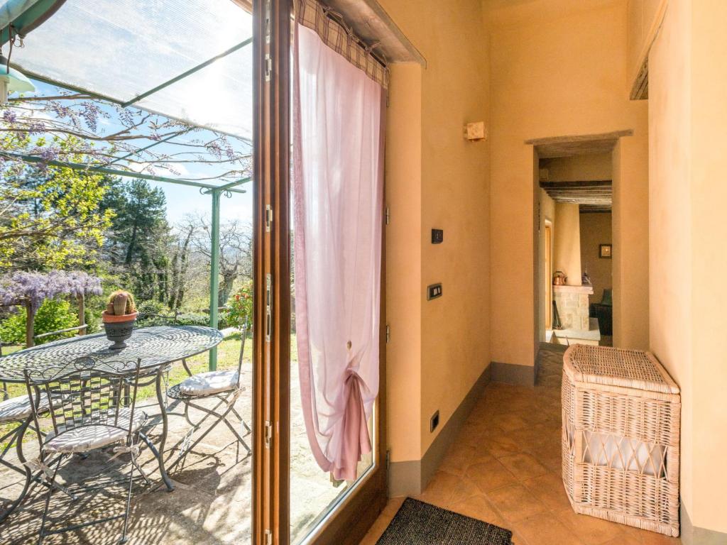 balkon ze stołem, krzesłami i szklanymi drzwiami w obiekcie Holiday Home La Casetta by Interhome w mieście Sassofortino