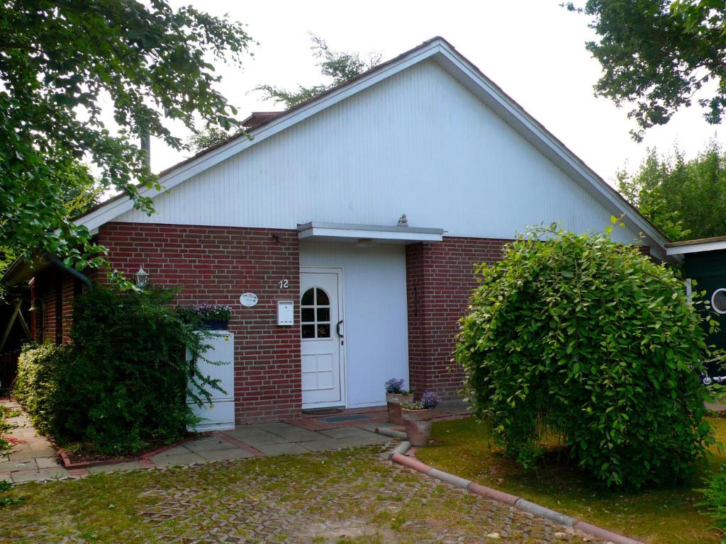 オッテルンドルフにあるHoliday Home Achtern Diek by Interhomeの白赤レンガ造りの家