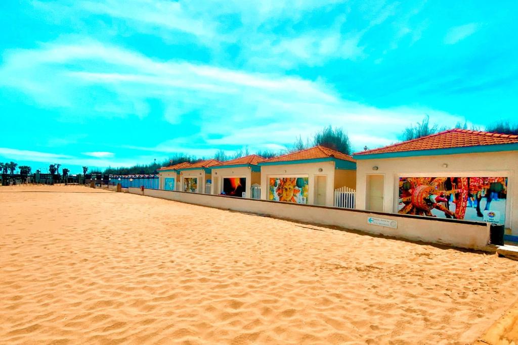 una fila de casas en una playa de arena en Villaggio Albergo Internazionale La Plaja, en Catania