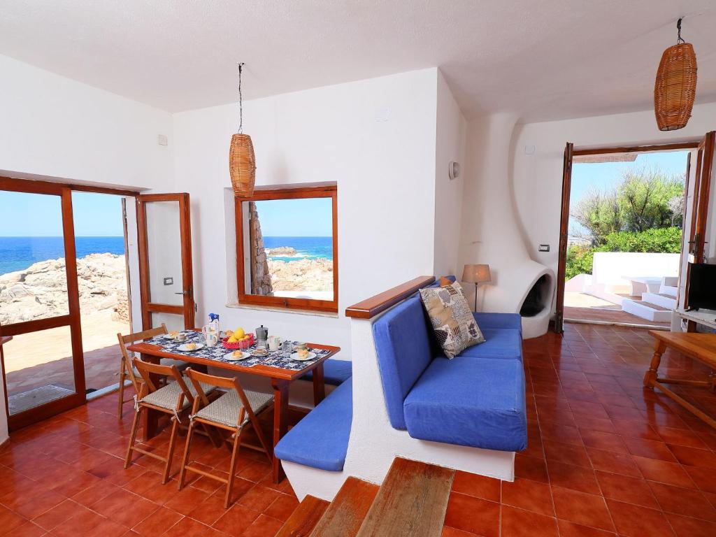salon ze stołem i niebieską kanapą w obiekcie Holiday Home La Cala - VGM615 by Interhome w mieście Aglientu
