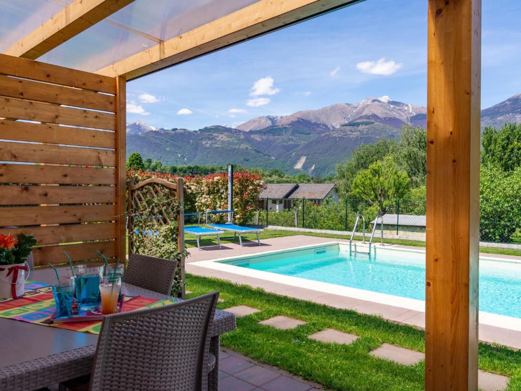 taras ze stołem i krzesłami oraz basenem w obiekcie Holiday Home Gelsomini - CCO521 by Interhome w mieście Colico