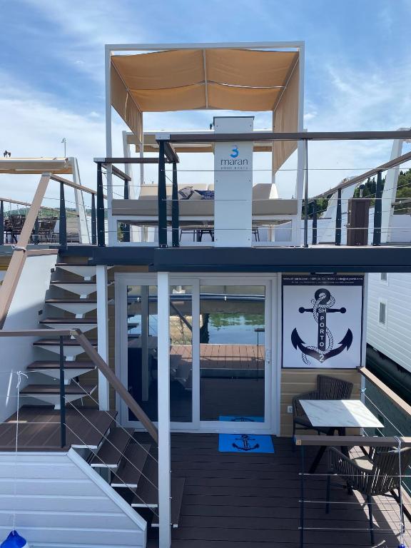 a deck of a boat with stairs and a table at SH Porto 2 Floating House, Marina Portorož in Portorož