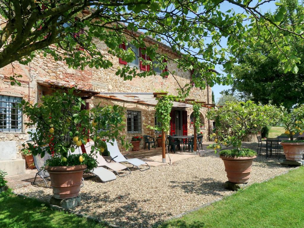 a house with chairs and trees in front of it at Holiday Home Ambrogetta by Interhome in San Casciano in Val di Pesa