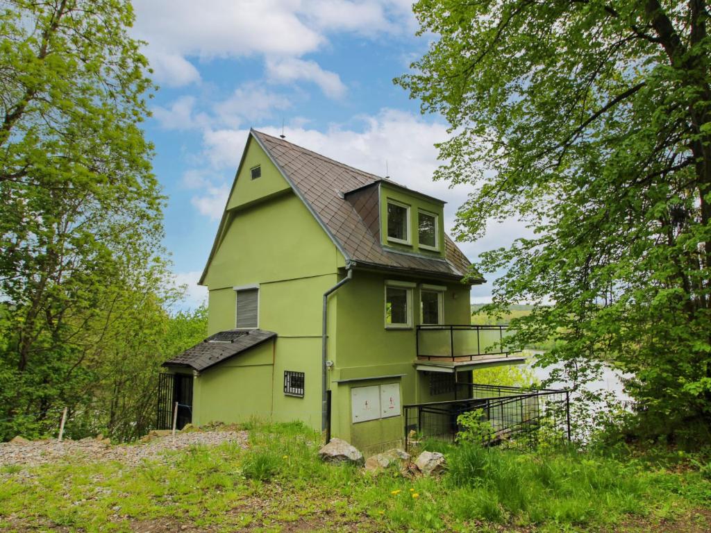 a green house on top of a hill with trees at Holiday Home Neznašov by Interhome in Neznašov