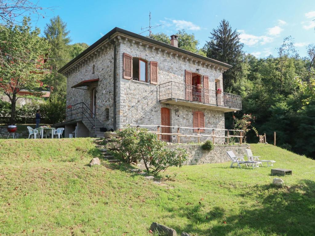 ein altes Steinhaus auf einem Hügel mit einer Bank in der Unterkunft Holiday Home di Elsa by Interhome in Brezzo