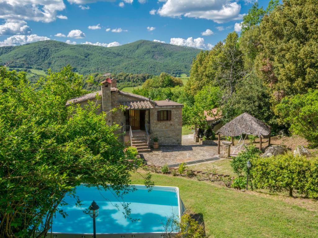 una vista exterior de la casa y la piscina en Holiday Home Casale Ulisse by Interhome en Roccastrada