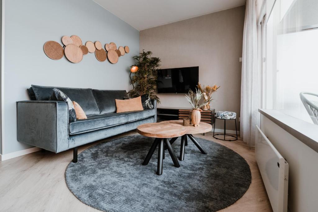 uma sala de estar com um sofá e uma mesa em Duinstraatje 15 em Zoutelande