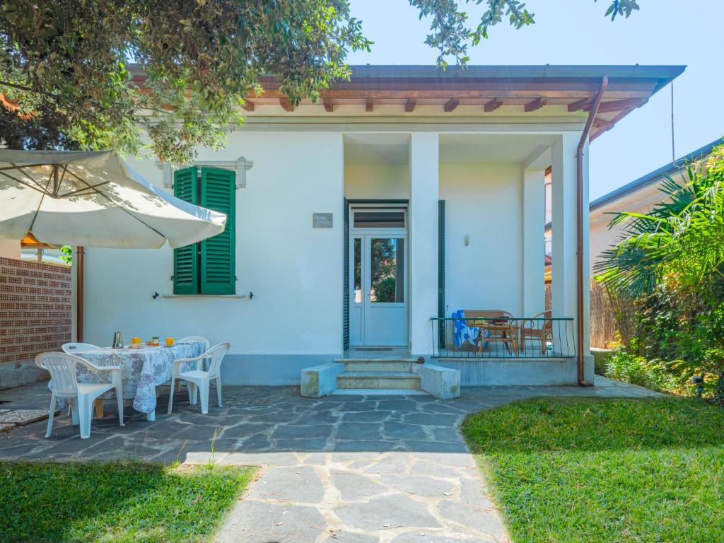 Biały dom ze stołem i parasolem w obiekcie Villa Anita by Interhome w mieście Marina di Pietrasanta