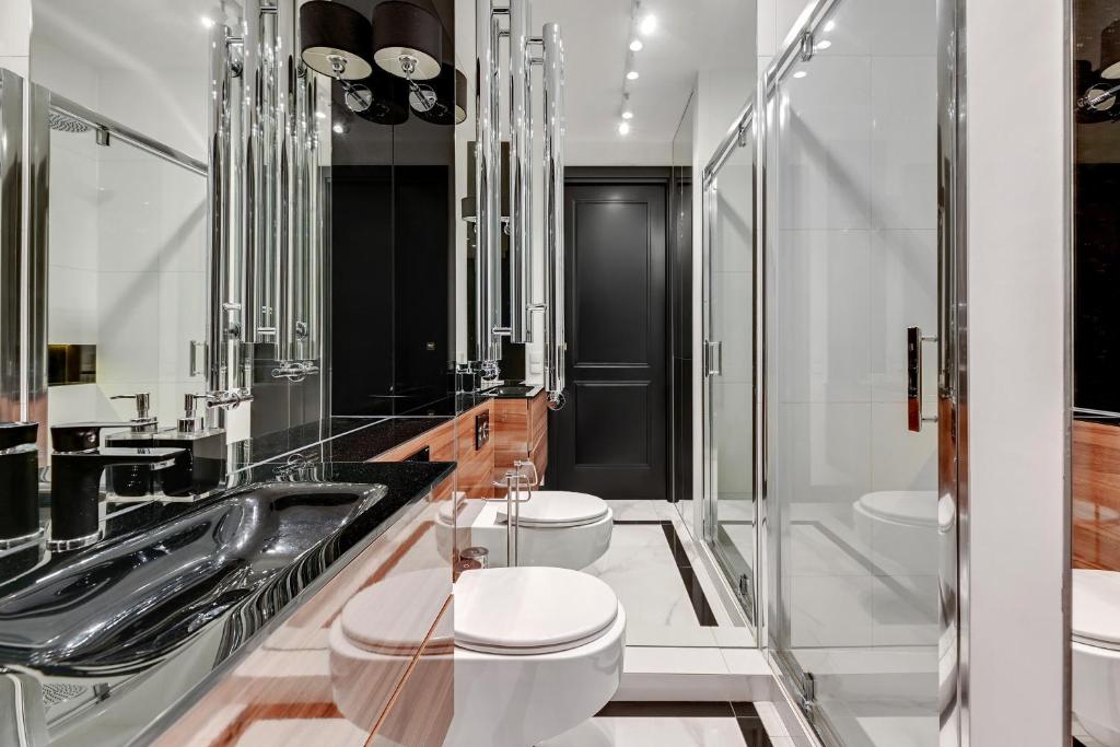 a bathroom with two toilets and a sink at Dom & House - Apartments Old Town Tartaczna in Gdańsk