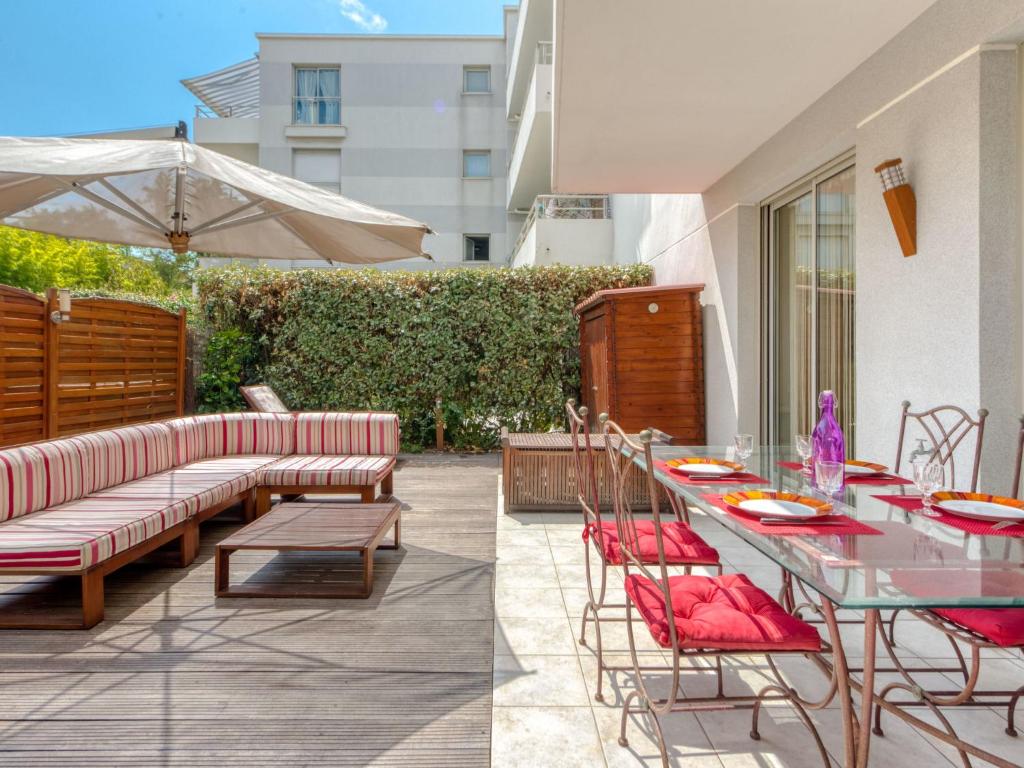 two pictures of a patio with a table and chairs at Apartment Les allées du Cap-3 by Interhome in Antibes
