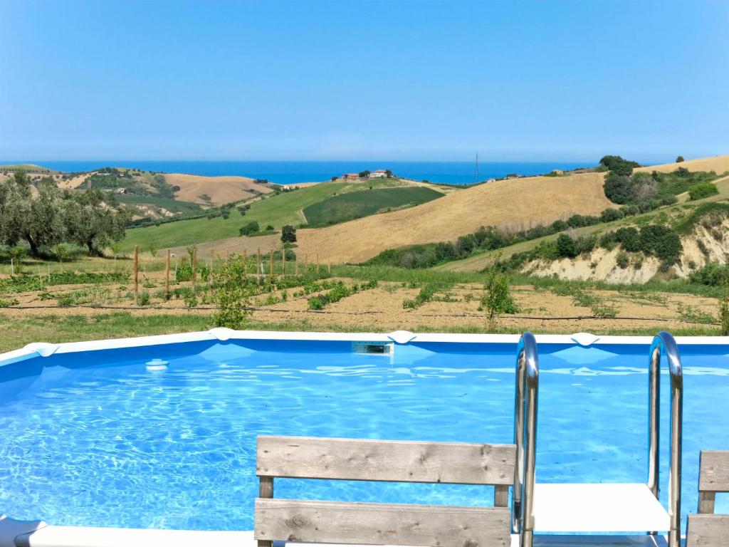 une piscine bleue avec un banc et l'océan dans l'établissement Holiday Home Serrani-4 by Interhome, à Cologna