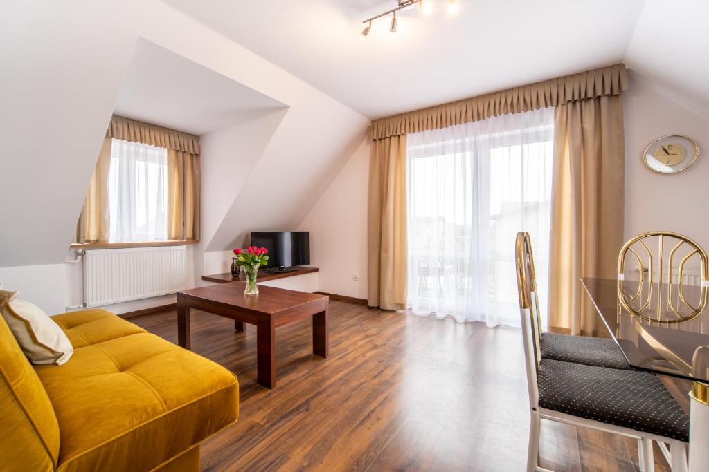 salon z żółtą kanapą i stołem w obiekcie Malwa w mieście Międzywodzie