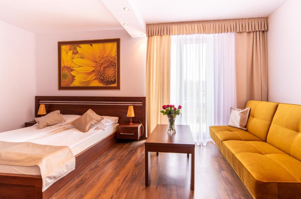 pokój hotelowy z łóżkiem i kanapą w obiekcie Malwa w mieście Międzywodzie