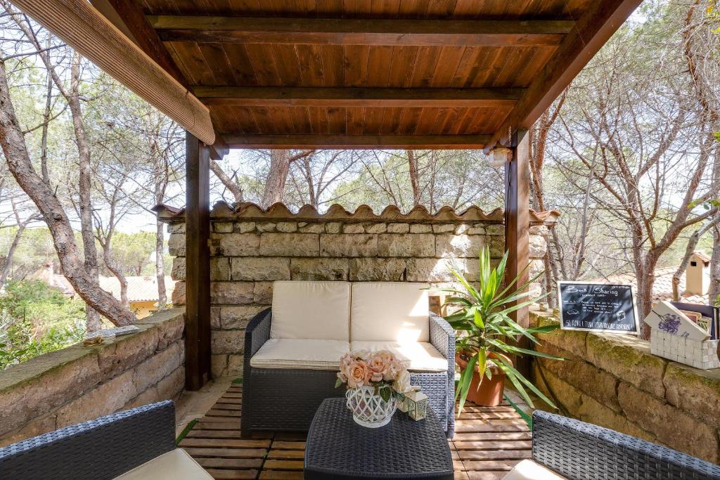 a pergola with a couch and chairs on a patio at Villa Viola in Narbolia
