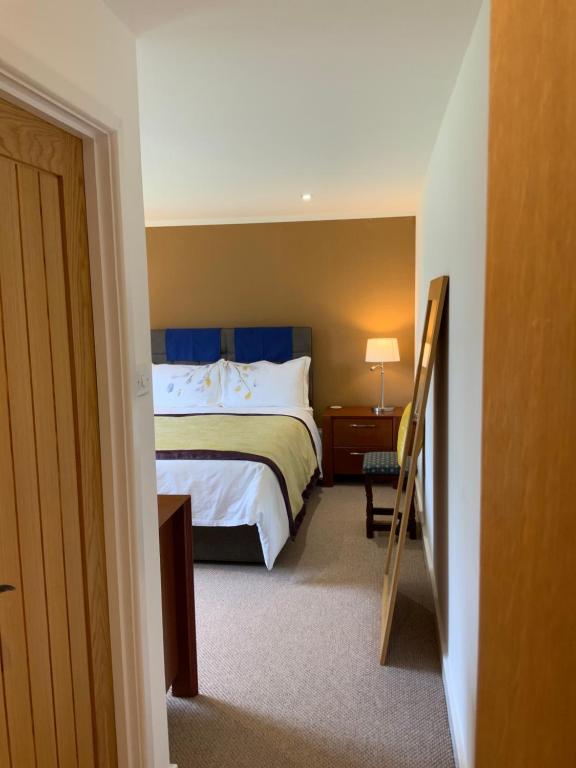 une chambre d'hôtel avec un lit et un escalier dans l'établissement West Lodge B&B, à Hailsham
