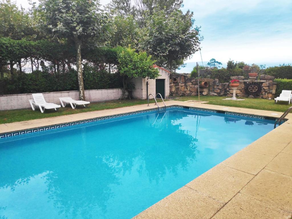 una piscina con acqua blu in un cortile di Apartamentos Revolta Sanxenxo 3000 a Revolta