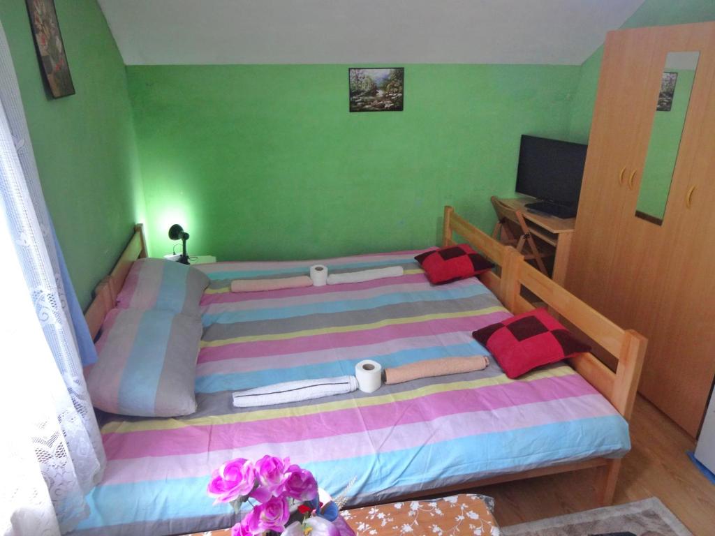 a small bedroom with a bed and a desk at Apartman MILENA in Foča