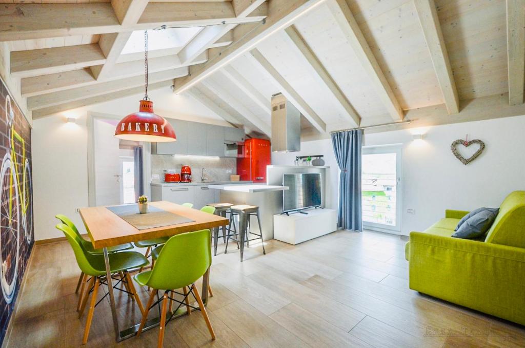 a kitchen and living room with a table and green chairs at Casa Tosca - Holiday Home in Nago-Torbole