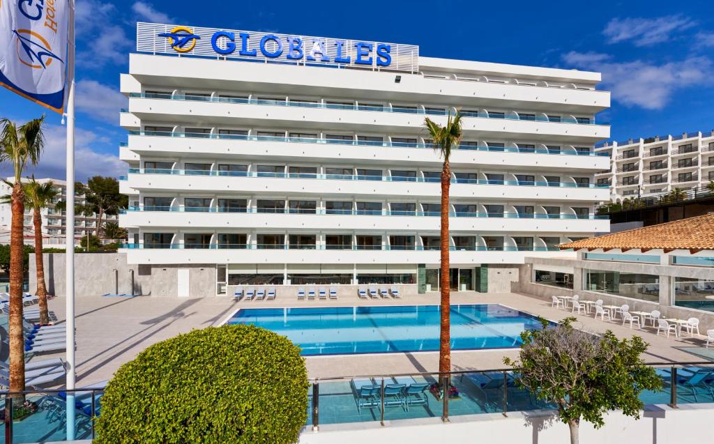un hotel con piscina frente a un edificio en Globales Torrenova en Magaluf