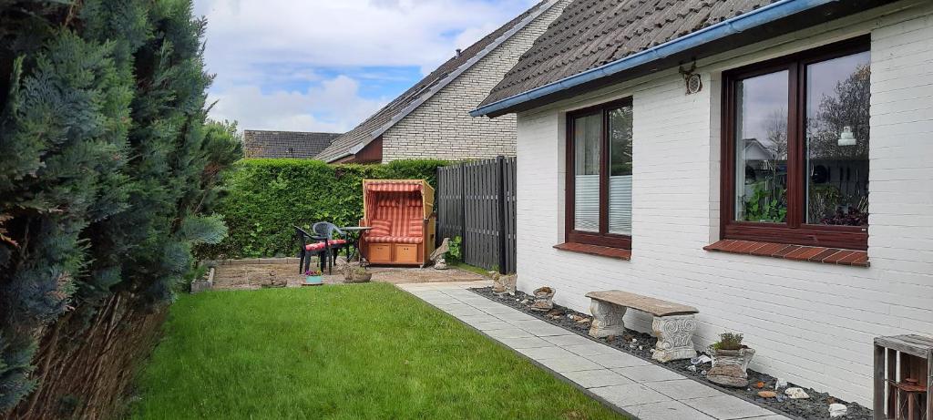 a house with a yard with a door and a window at Ferienwohnung Goden-Wind in Westerdeichstrich