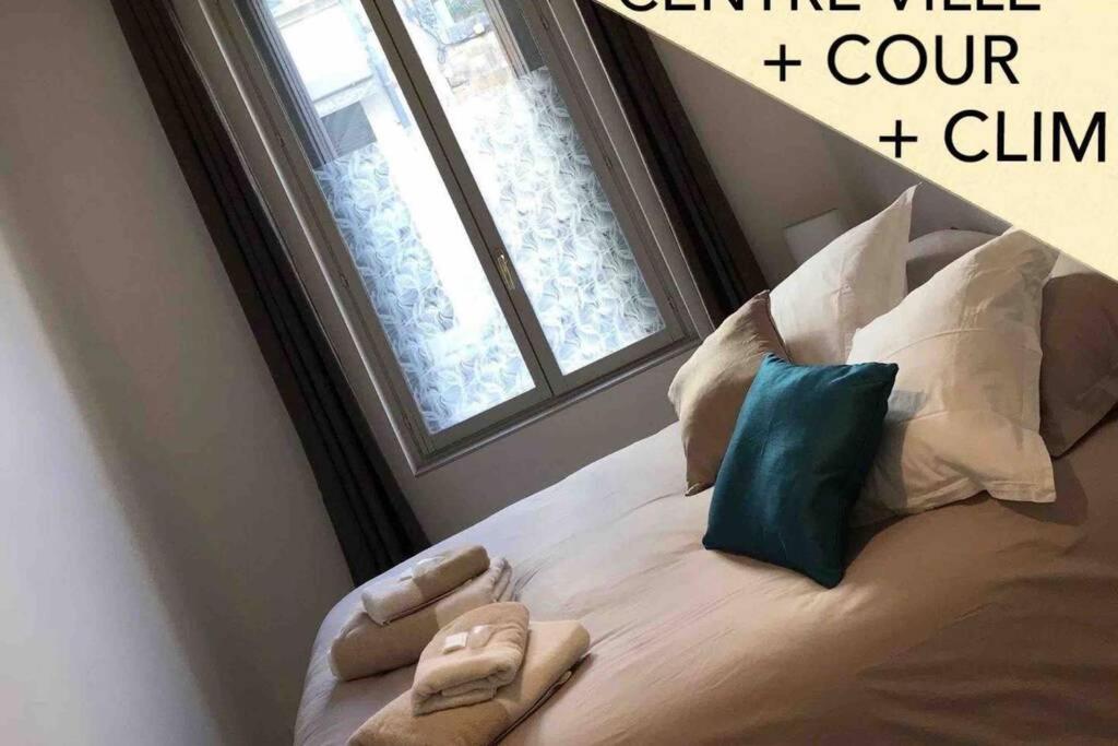 un lit avec deux pantoufles dessus dans une pièce avec une fenêtre dans l'établissement Studio au cœur de la ville d’Arles, à Arles