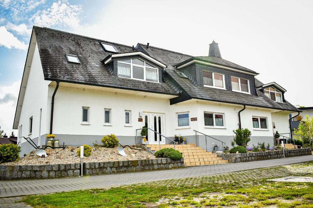 a white house with a black roof at Ferienhaus Magasch in Mittenwalde