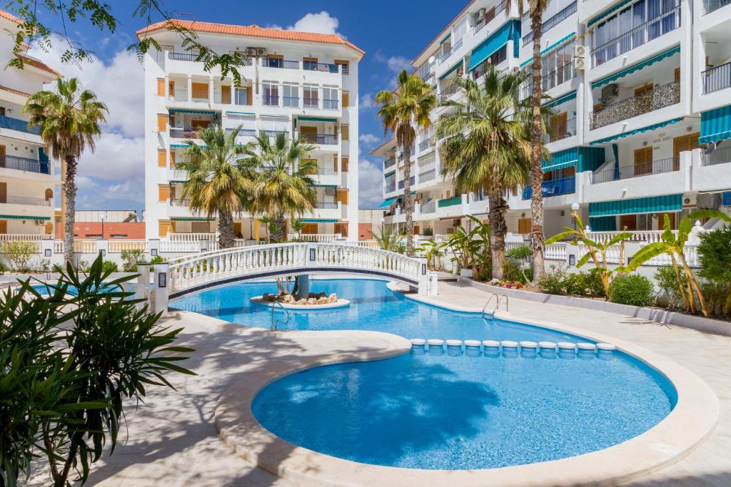 a swimming pool with a bridge in front of a building at La Mata Bélgica in La Mata