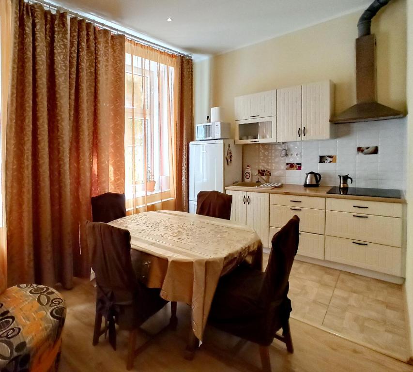 a kitchen with a table and some chairs and a kitchen with a table at Apartments IRIS in Karlovy Vary