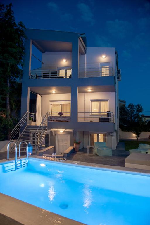 a villa with a swimming pool at night at Villa Kallisti in Iraklitsa