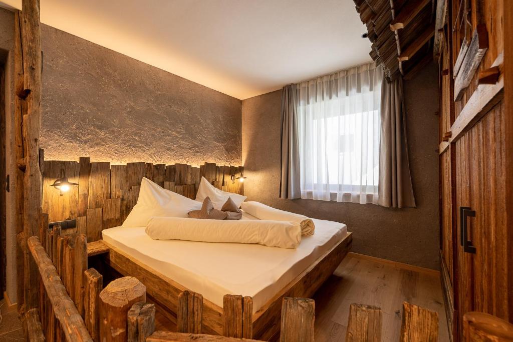 a bedroom with a bed made out of logs at Sonnleiten Sonnenalm in Collepietra