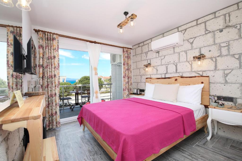a bedroom with a king sized bed and a balcony at Twins Hotel Çeşme in Cesme