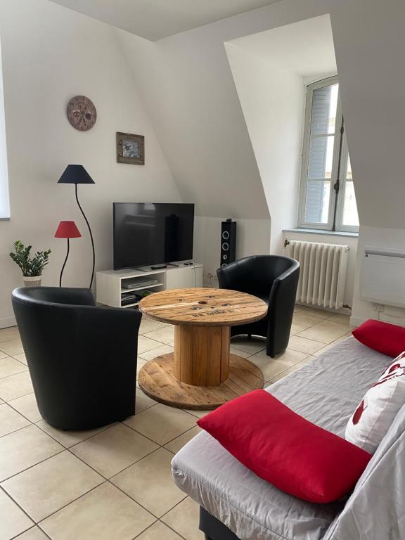 a living room with a table and a tv at La bourboule Appartement in La Bourboule
