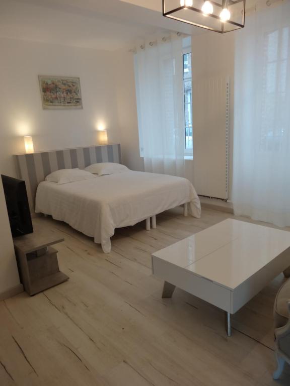 1 dormitorio con cama y mesa de centro en Les Petites Tuileries, en Bray-sur-Seine