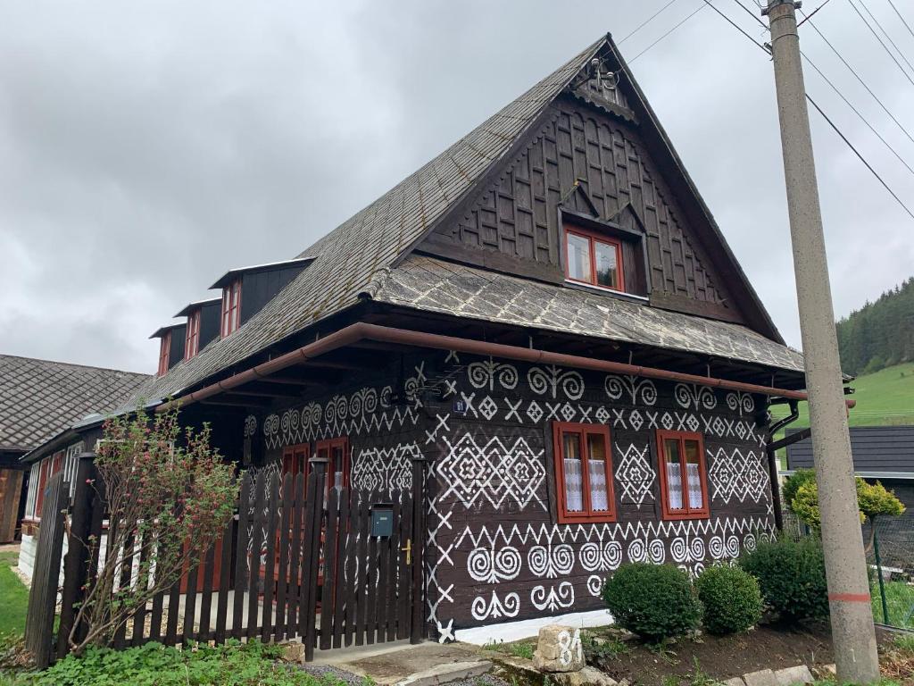 a black and white house with a black at Ondrejova drevenica in Čičmany