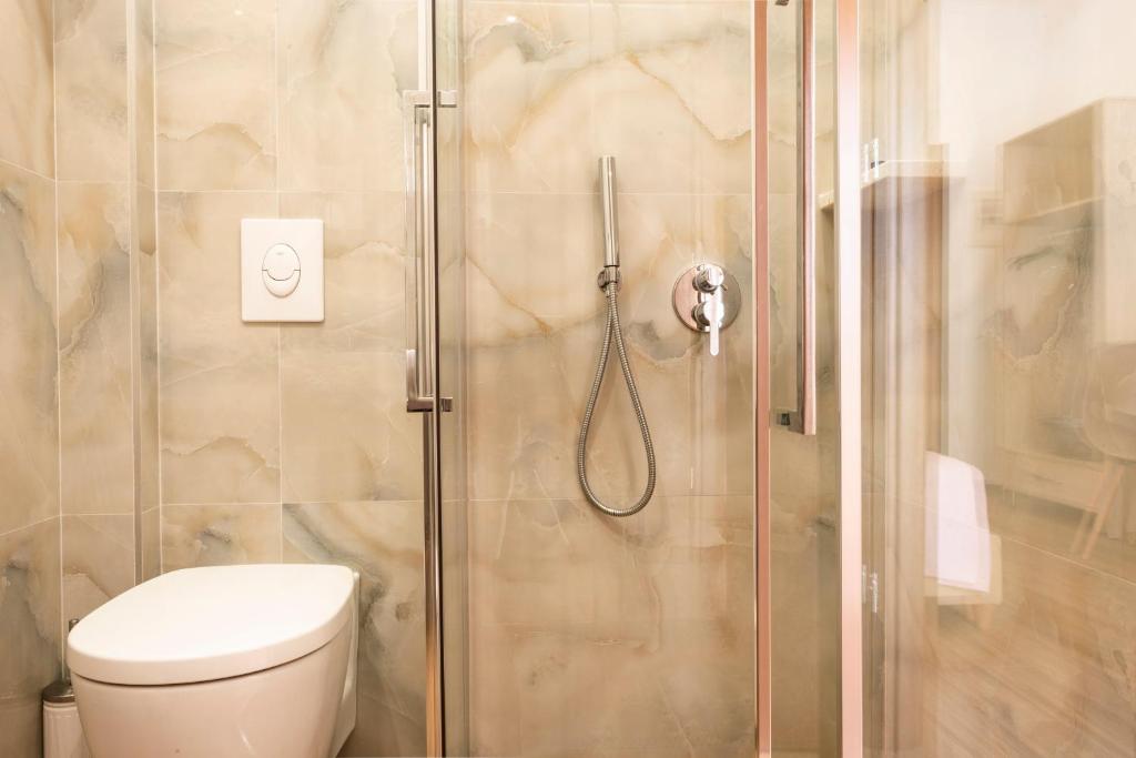 a bathroom with a shower with a toilet at sofia's cozy rooms in Himare