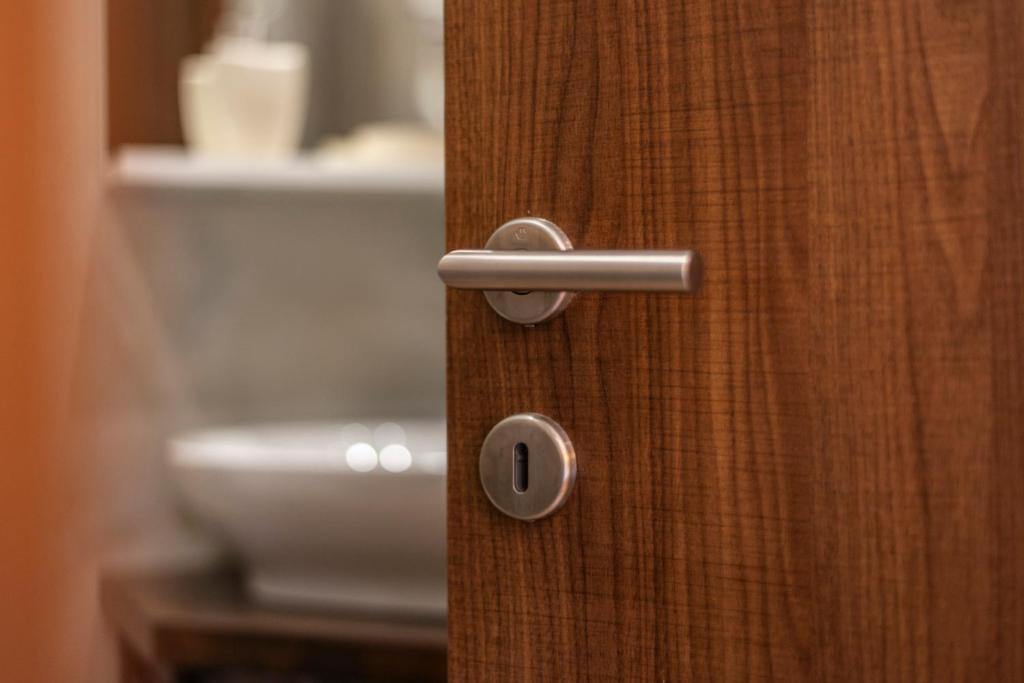 a wooden door with a handle in a bathroom at sofia's cozy rooms in Himare