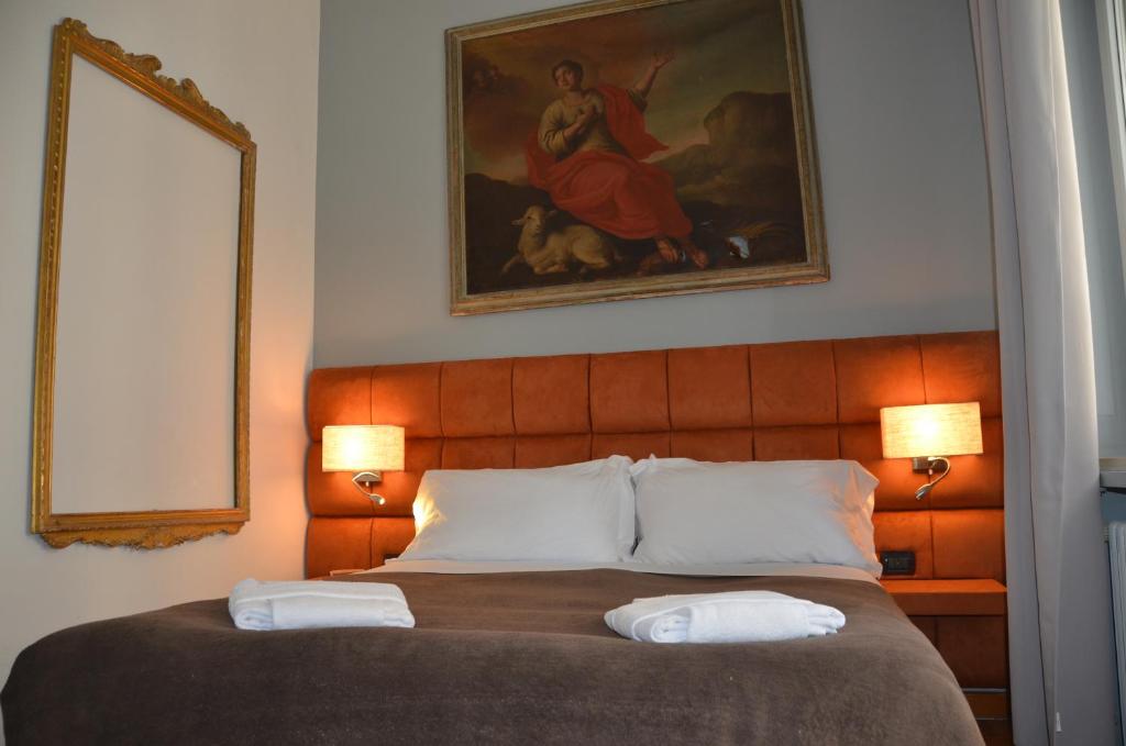 1 dormitorio con 1 cama con 2 lámparas y 1 pintura en Sweet Home Parioli, en Roma
