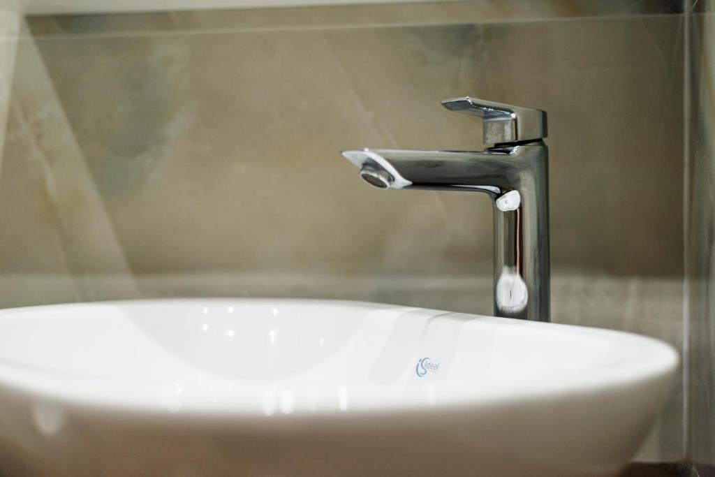 a sink with a faucet in a bathroom at sofia's cozy rooms in Himare