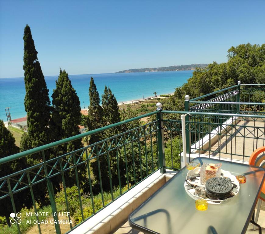 a table on a balcony with a view of the ocean at Miloni Studios in Lourdhata