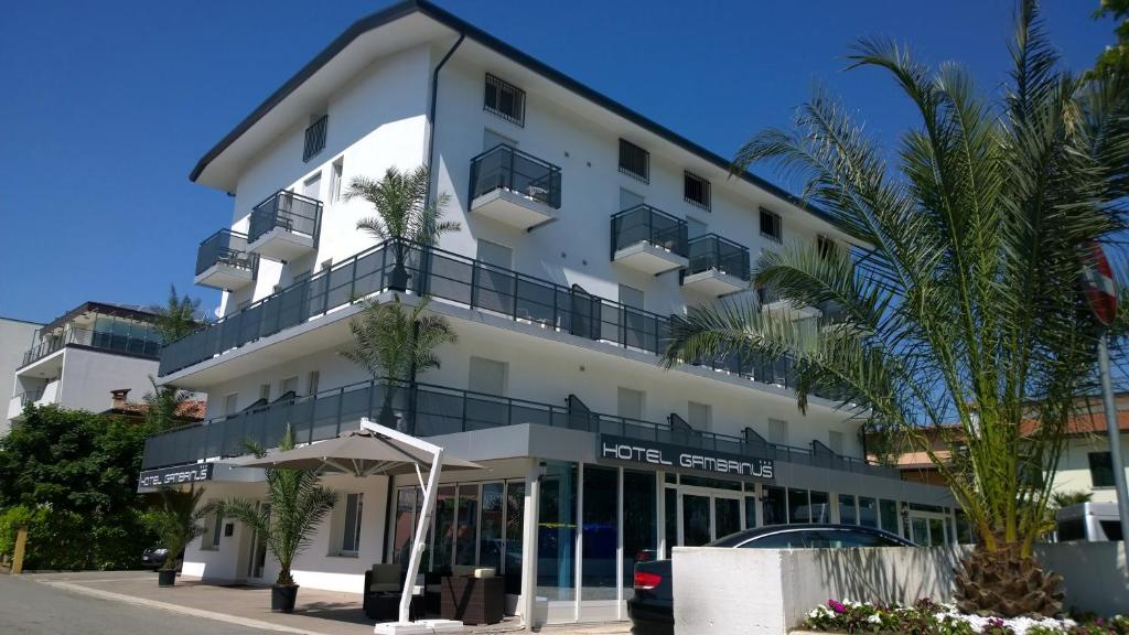a white building with a lot of balconies on it at Hotel Gambrinus in Lignano Sabbiadoro