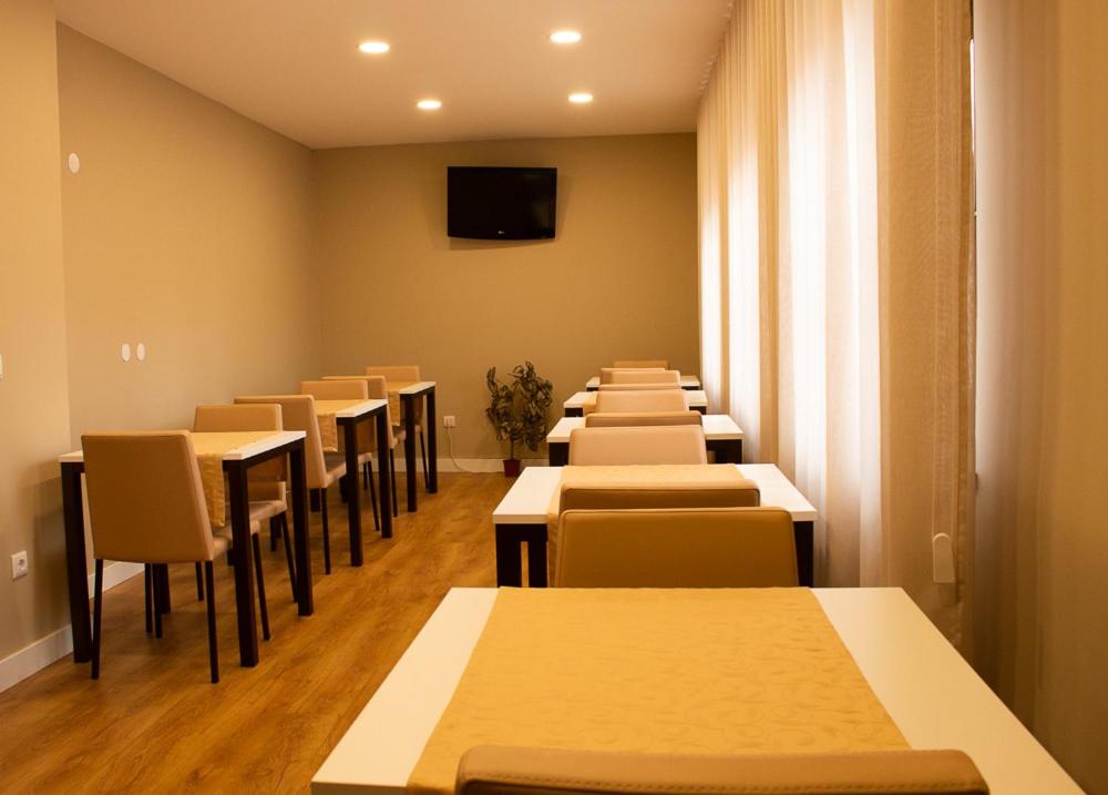 una fila de mesas y sillas en una habitación en Gouveia Residence, en Coímbra