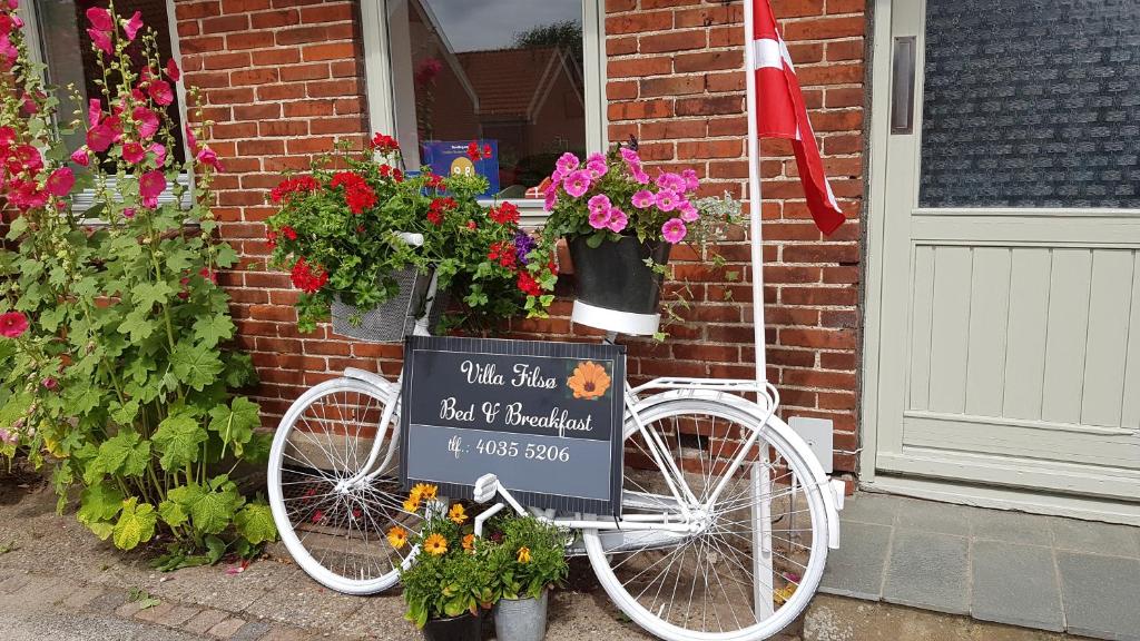TimにあるB&B Villa Filsøの家の横に看板を持つ白自転車