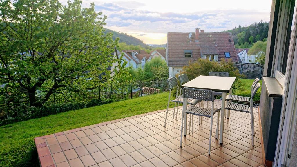 un patio con tavolo e sedie sul balcone. di GreenCorner - Sonnige Terrasse 1-6p a Reichenbach