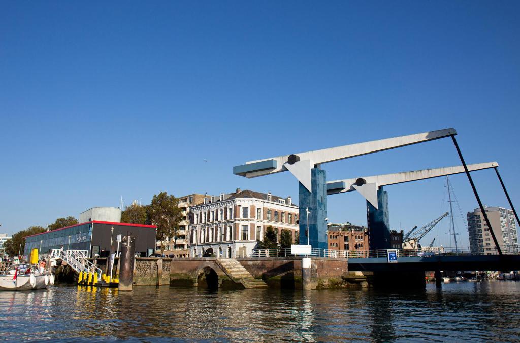 un pont sur une masse d'eau avec des bâtiments dans l'établissement Suitehotel Pincoffs, à Rotterdam