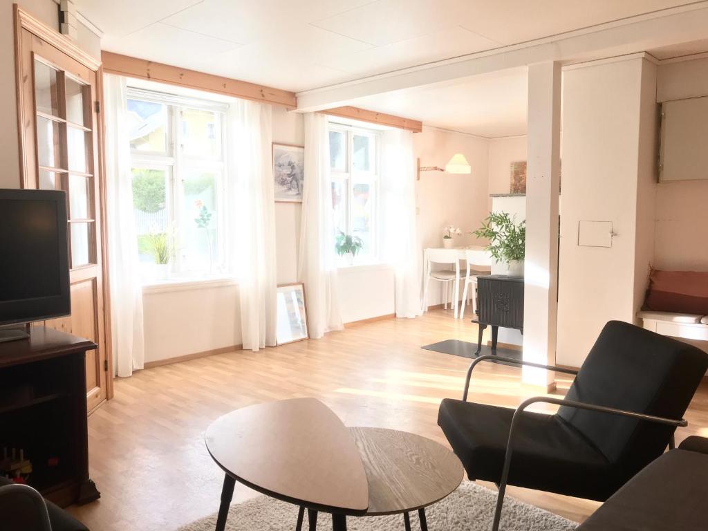 a living room with a couch and a table at Villa Holmen, ground floor apartment in Balestrand