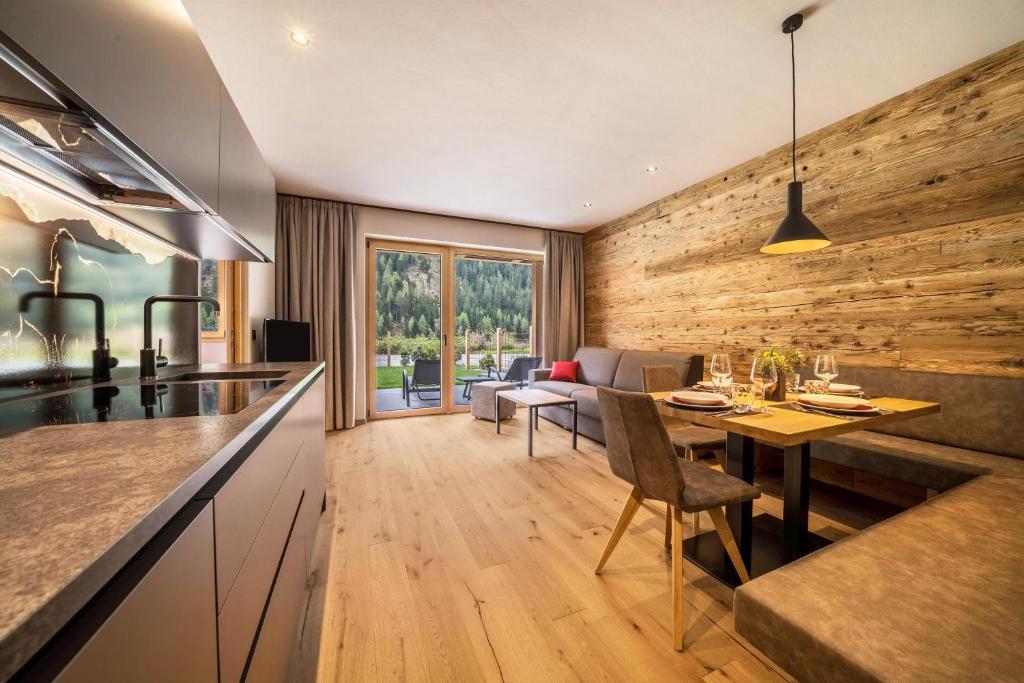 cocina y sala de estar con pared de madera en Seebrunn - Kuppelwieser Alm, en Ultimo