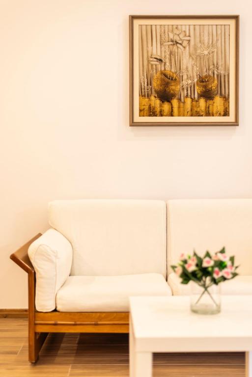 a living room with a white couch and a table at sofia's cozy rooms in Himare