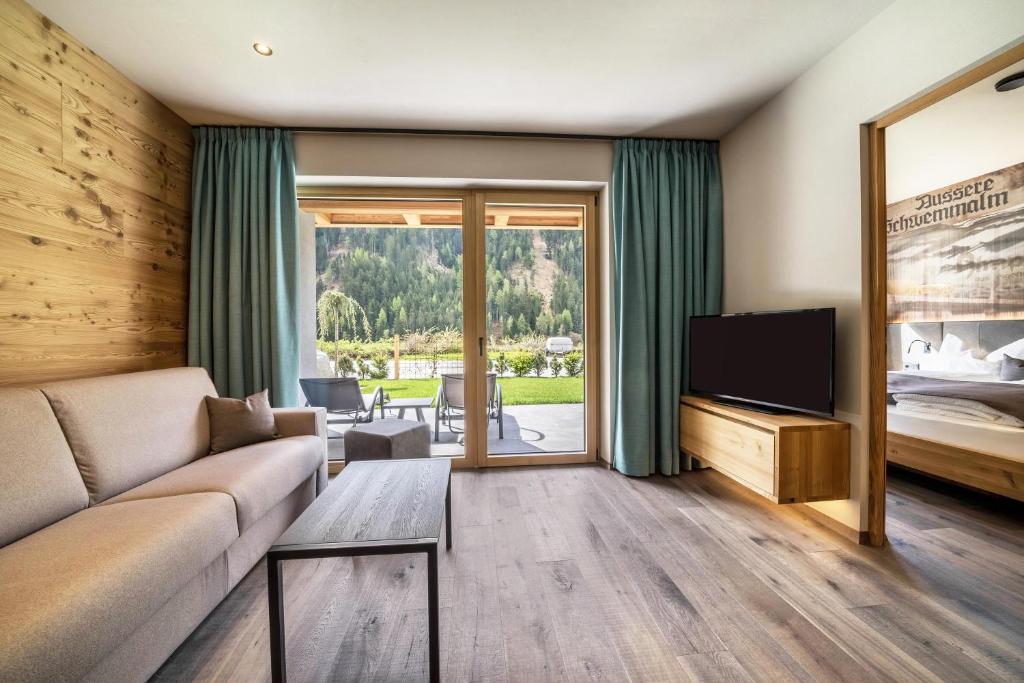 ein Wohnzimmer mit einem Sofa und einem TV in der Unterkunft Seebrunn - Außere Schwemmalm in Ulten